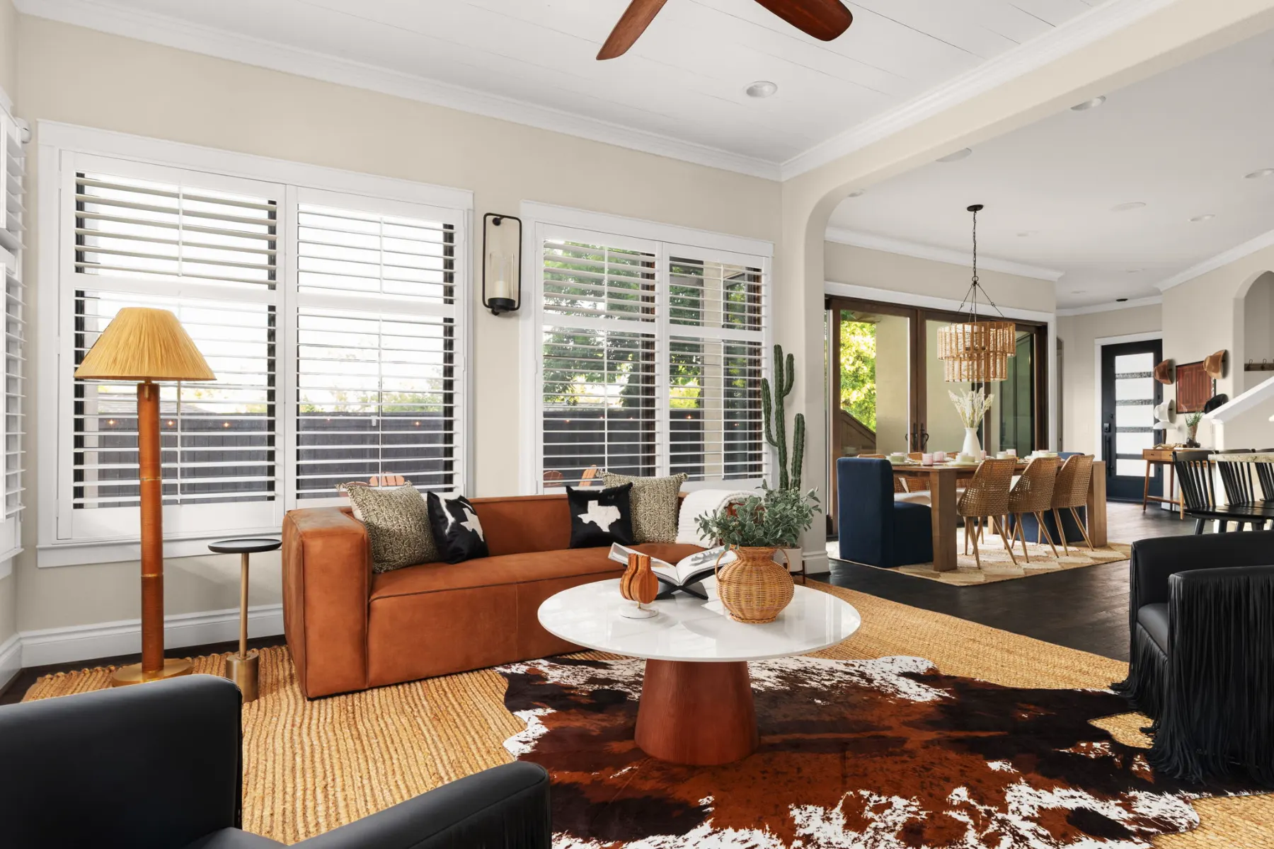 Sunset Saloon: a living room with a cognac leather sofa, a cowhide rug and the dining area beyond